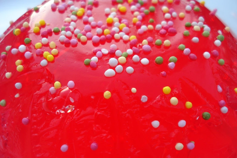 a frosted red cake with colorful sprinkles