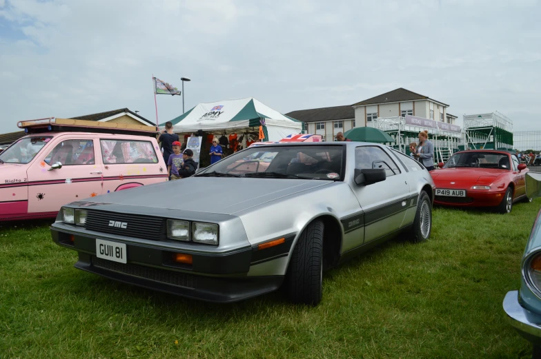 cars parked in the grass at an automobile show