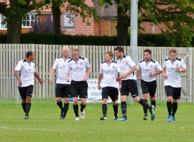 the boys are wearing white shirts playing soccer