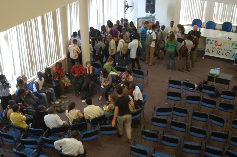 a room filled with chairs and people standing around