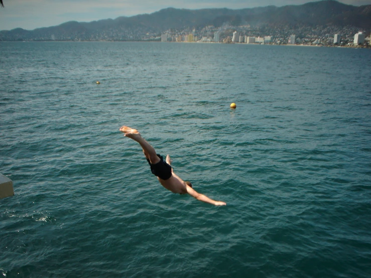 a man is diving into the water from a platform