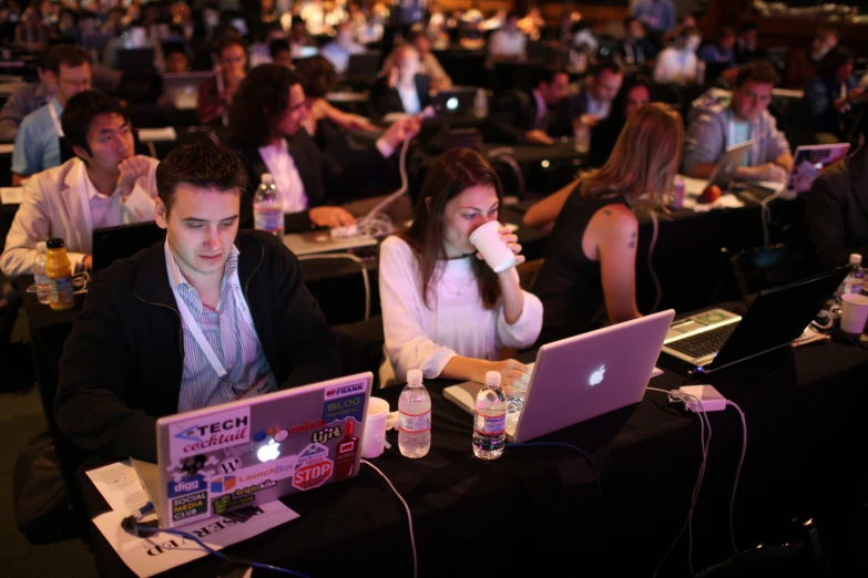 two people on laptops in a business conference