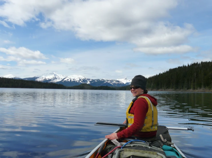 a man paddles his canoe in the water while looking back