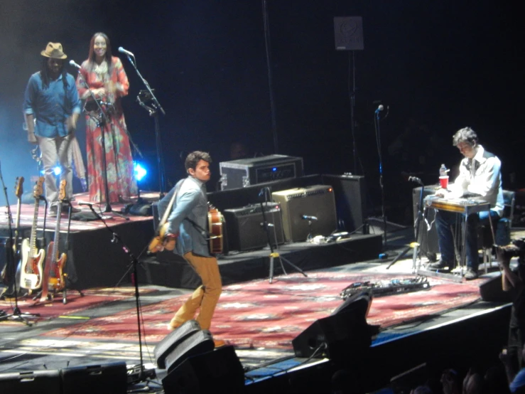 a woman on stage with people watching in the background