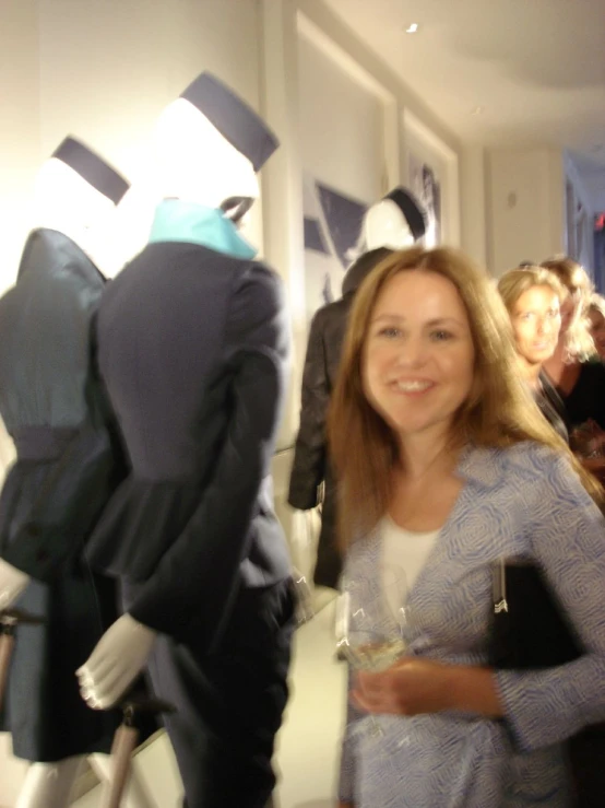 a woman standing next to a group of mannequins