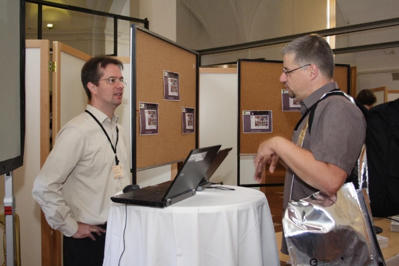 two men in a room with cork boards