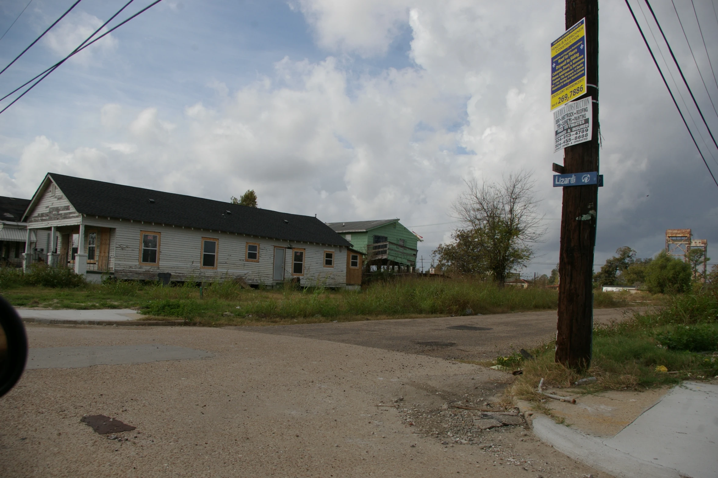 a large sign next to a road with two buildings