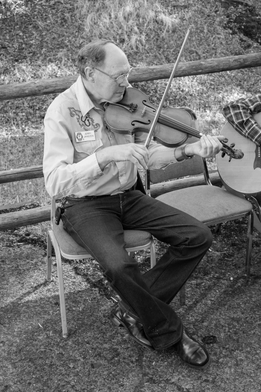 a man sitting on top of a chair holding a violin