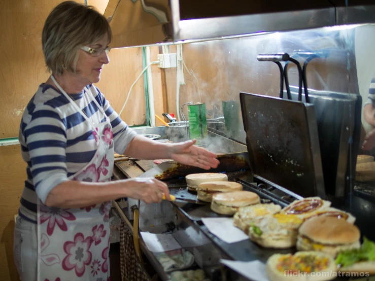 the woman is preparing sandwiches on the grill