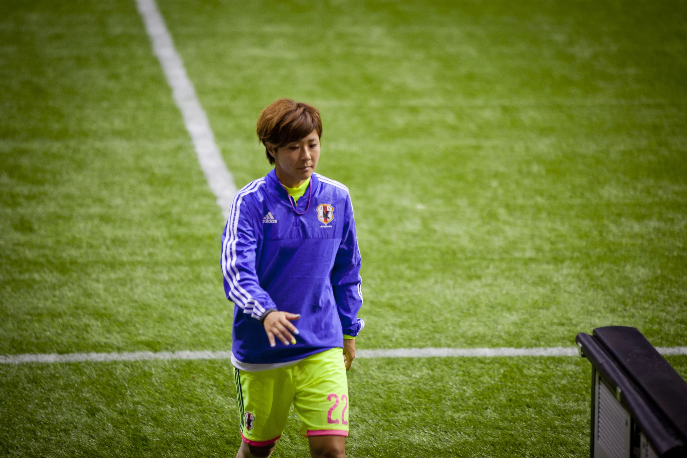 young man in a blue and green uniform warming up