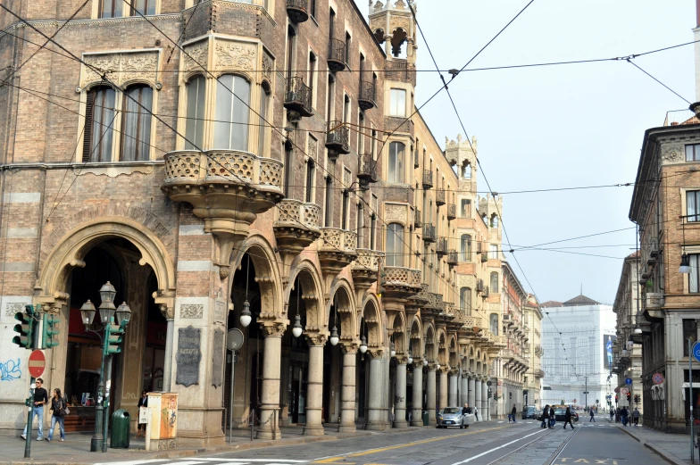 a large street with a long building lined with ornately shaped columns