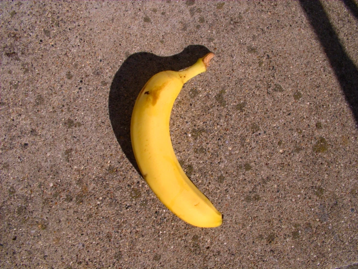 a banana on a sidewalk next to some concrete