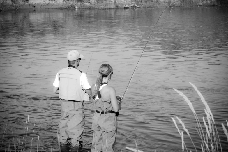 a man and woman fishing from shore in the lake