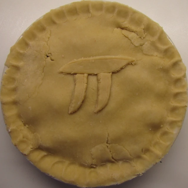a pie with a bird carved on it is next to another piece of food