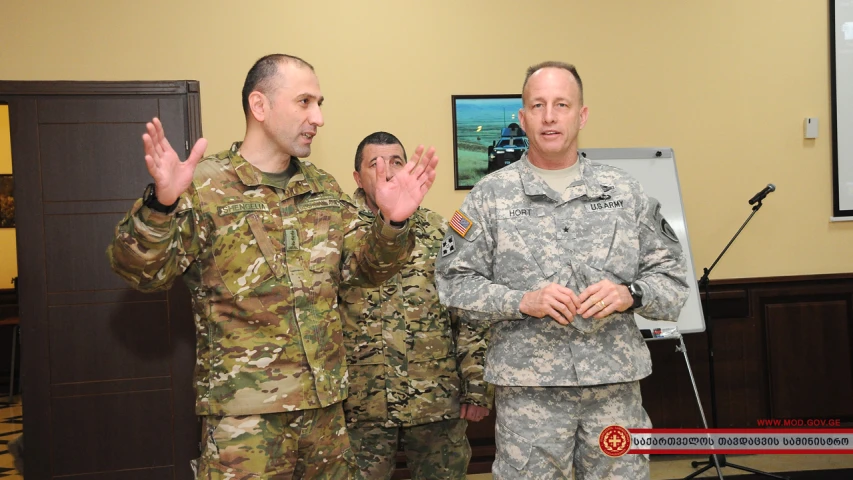 two military men in uniform are applauding while they hold up their hands