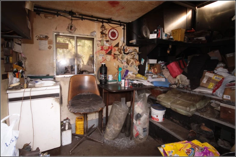 a cluttered kitchen with a table and chairs