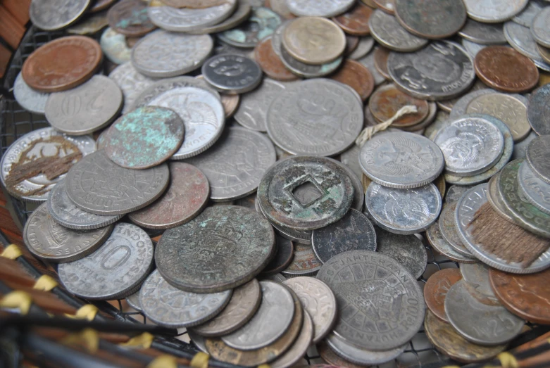 many different coins in the basket and on the floor