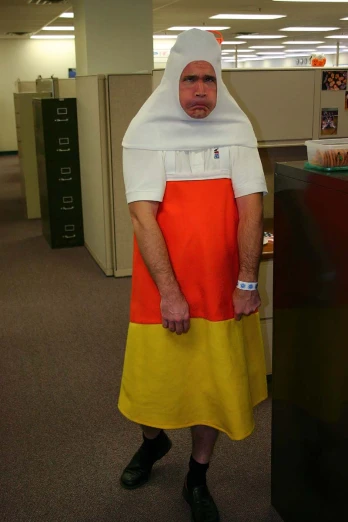 a man wearing a large headpiece standing in an office