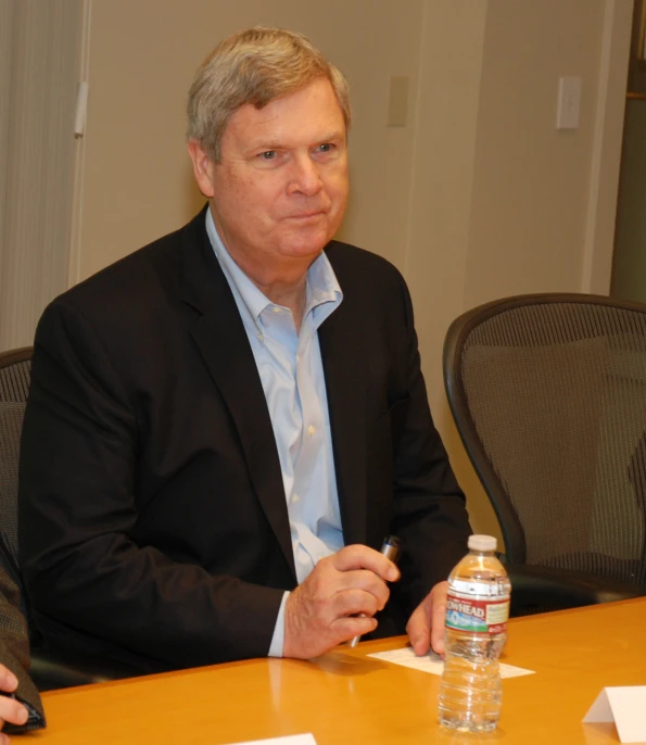 a man sitting at a table with a bottle in his hand