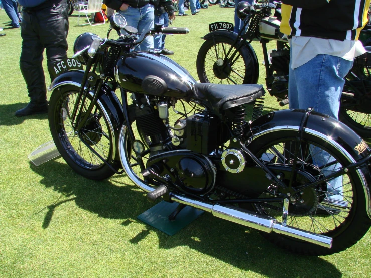 a black motorcycle on a grassy field at a show