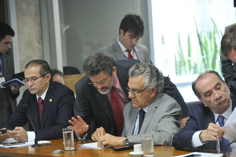 several men in suits and ties around a wooden table