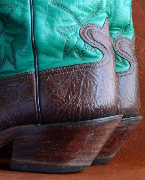 a pair of cowboy boots are lined up against a wooden surface