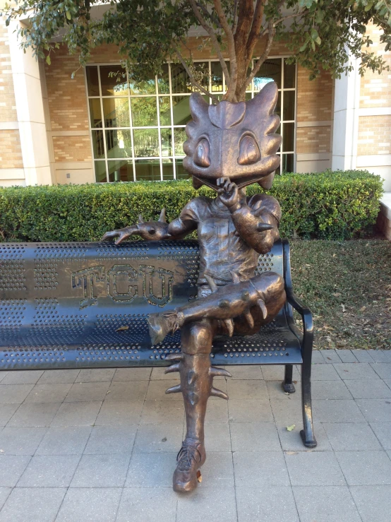 a metal sculpture of a woman sitting on a bench