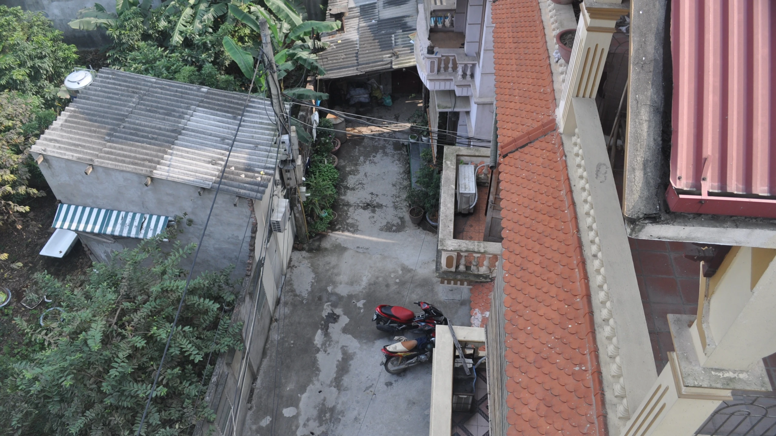 a small street in front of some buildings and parked vehicles