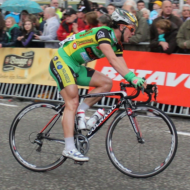 a man riding on the front of a bike next to a crowd