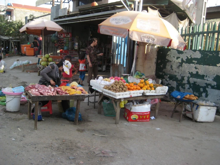 a couple of people stand under an umbrella in a market