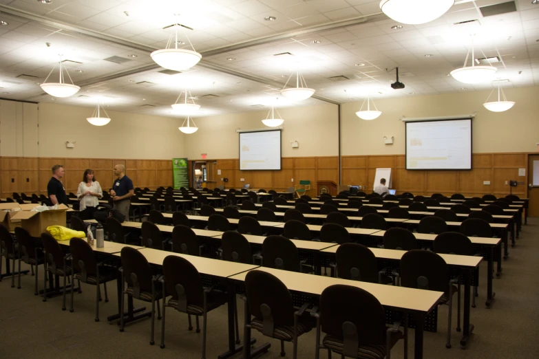 a lecture hall filled with black desks and long tables