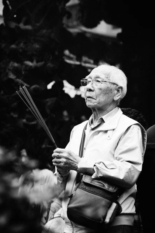 an old man holding bamboo sticks in his hands