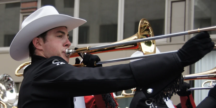 a man in a white hat playing the trombone