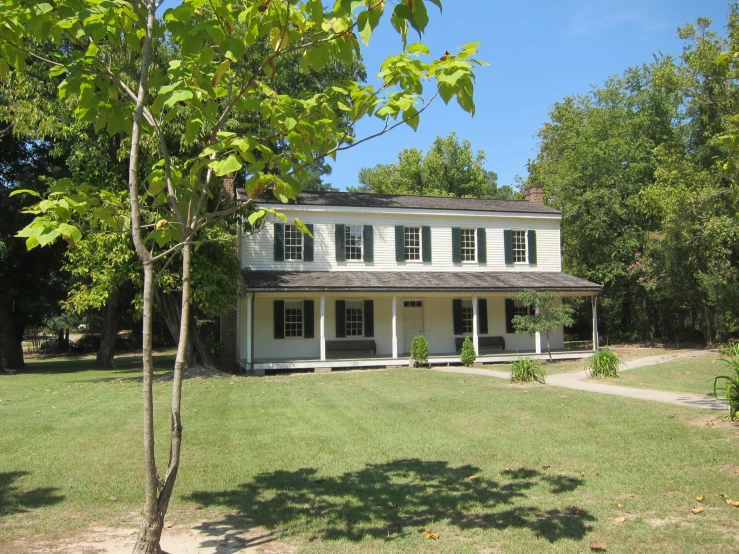a large house is shown in front of trees