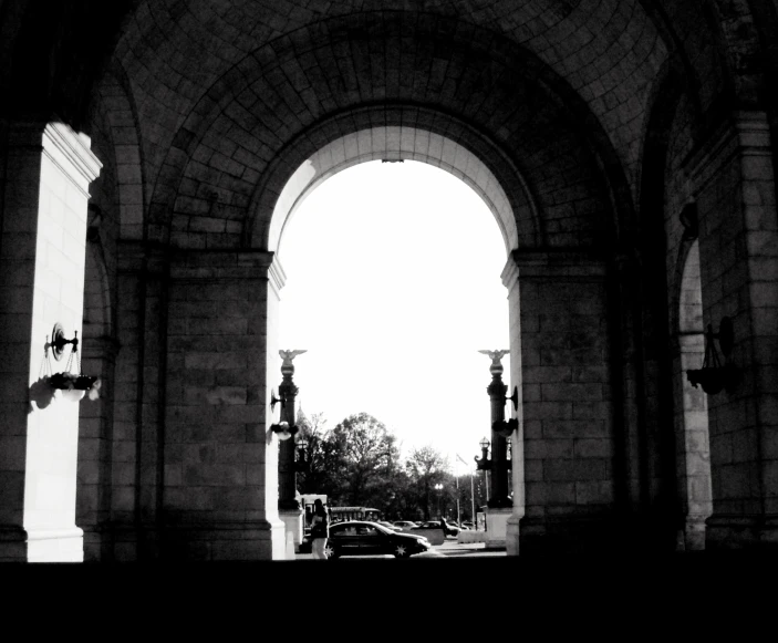 an arch with lights on it with traffic in the background