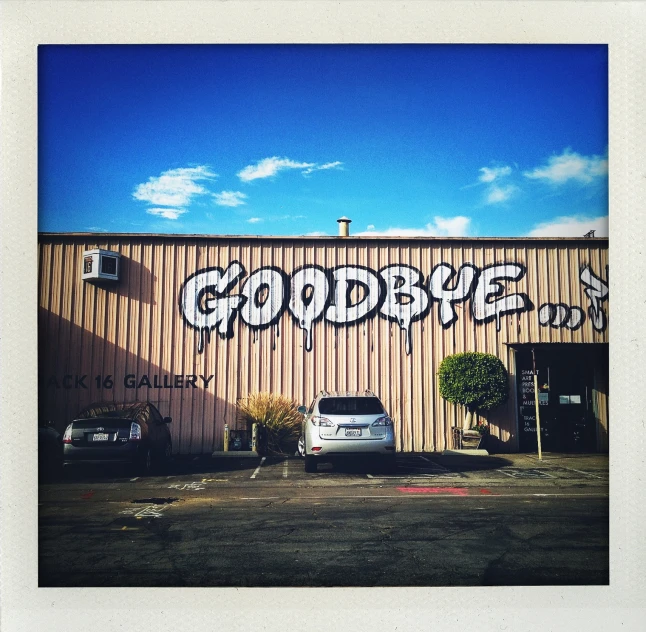 a parking lot and a large building with graffiti on the side