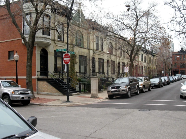 a street is filled with parked cars and trees