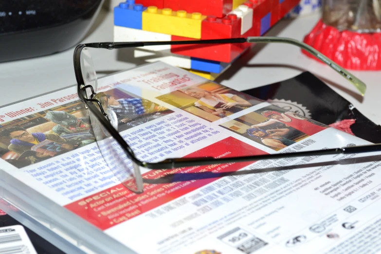 glasses resting on top of a magazine with pos inside
