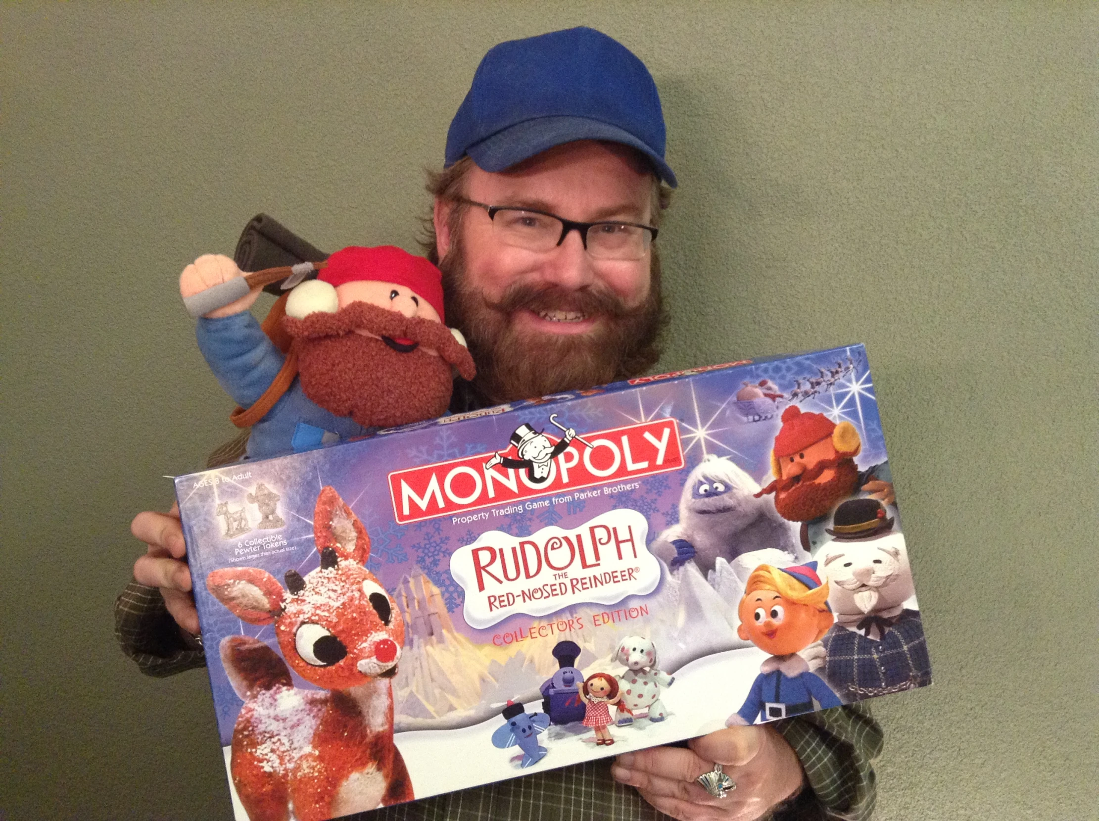 man holding up a monopoly book with several stuffed animals