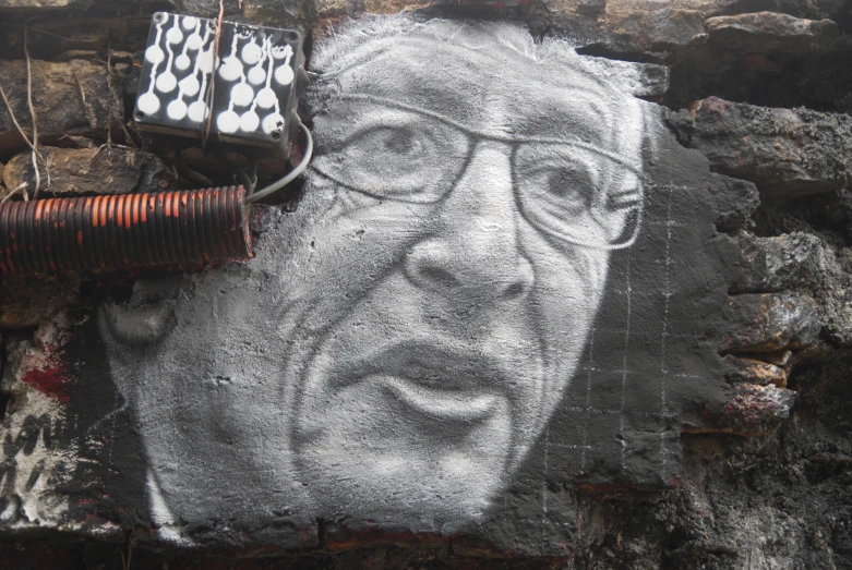 a wall with a graffiti drawn on it of a man with glasses and the words bill gates is beside it