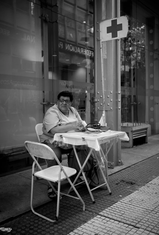 man sitting in chair in front of a glass store