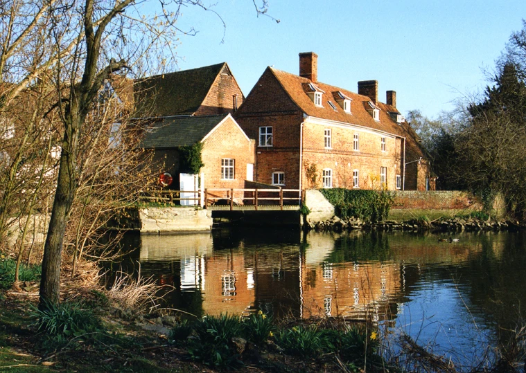 a large house sits at the end of a small river
