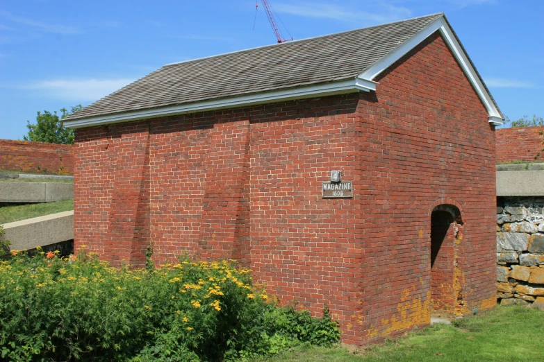 the small brick building has a flag on the roof