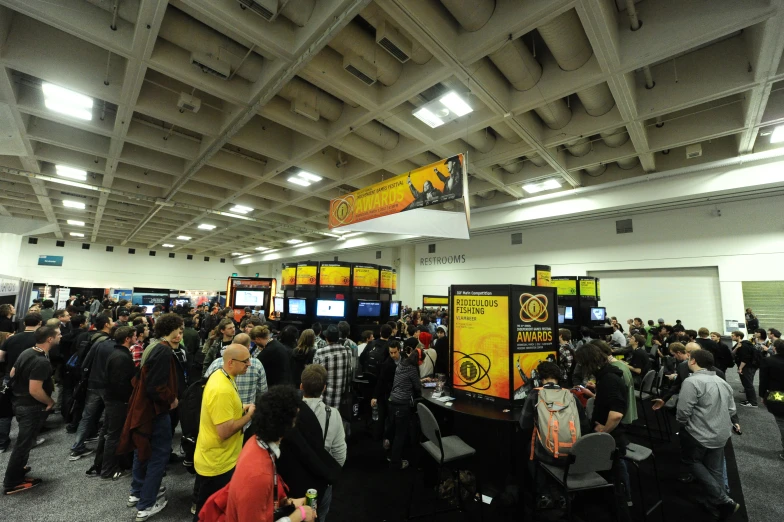 many people stand in a room full of arcade machines