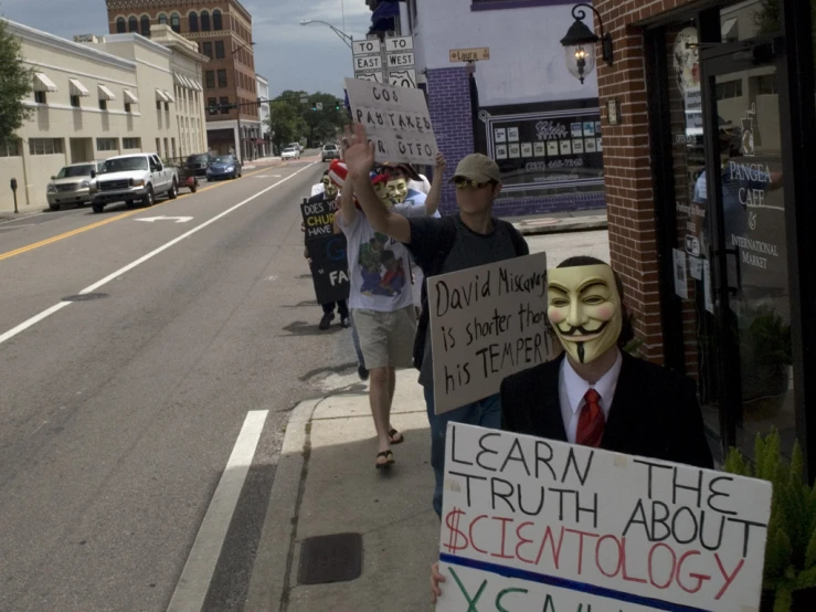 a group of people with masks standing on a street corner