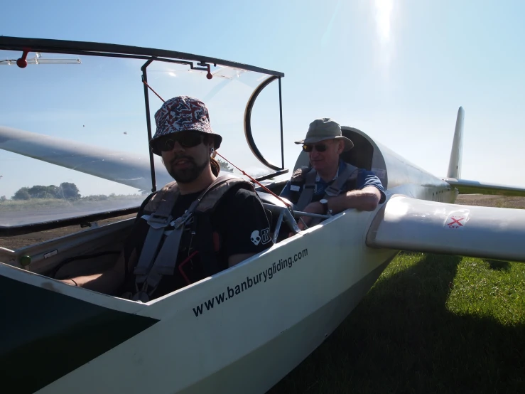 two men are sitting in a glider boat with their heads tilted