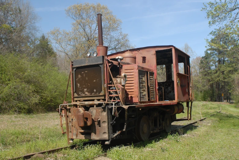 an old rusty train engine parked in a field