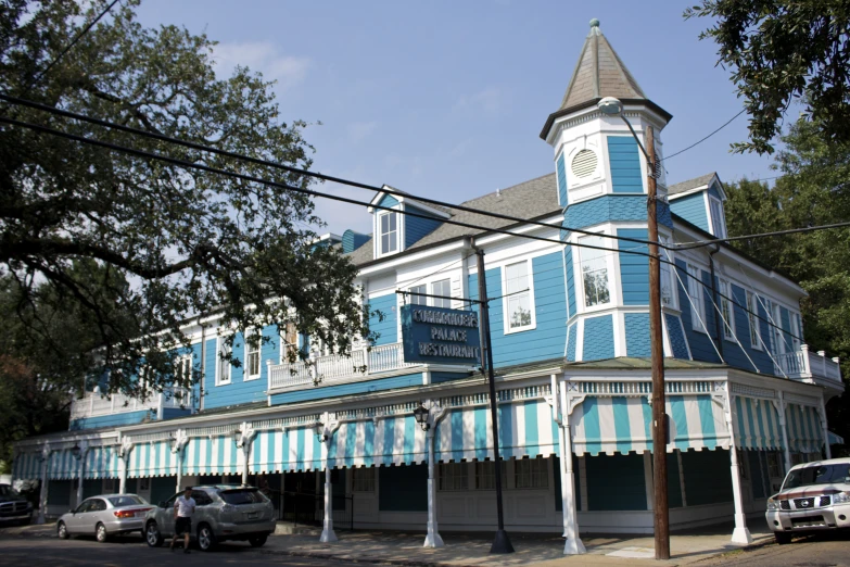 a blue building on the street corner with cars parked in front