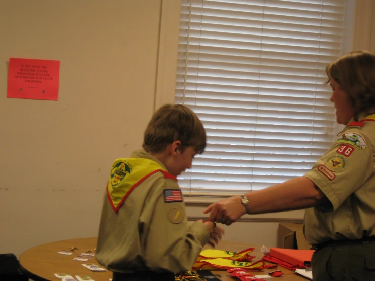 a boy scout is  up some cards