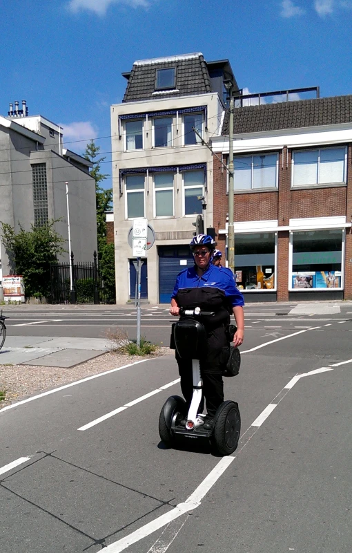 a man riding on an exercise scooter on a city street